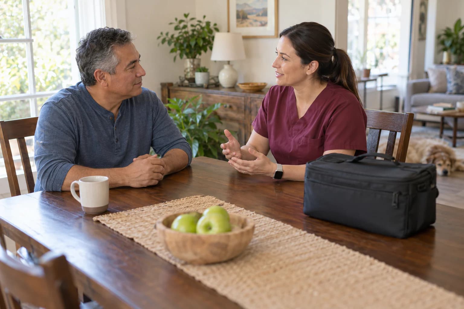 A client and mobile phlebotomist talk together in a comfortable home before a collection.